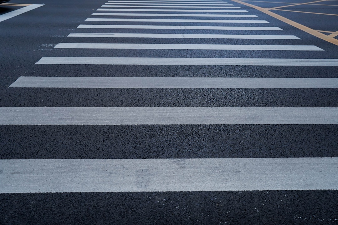 Crosswalk and stop bar markings at a desert intersection in Southern Nevada