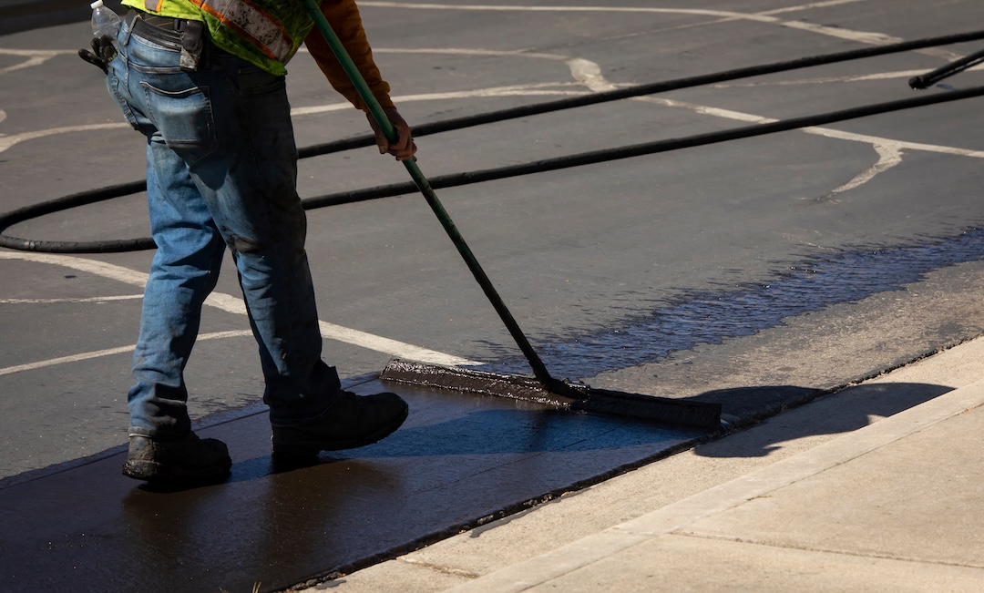 Sealcoating being applied to a commercial parking lot surface